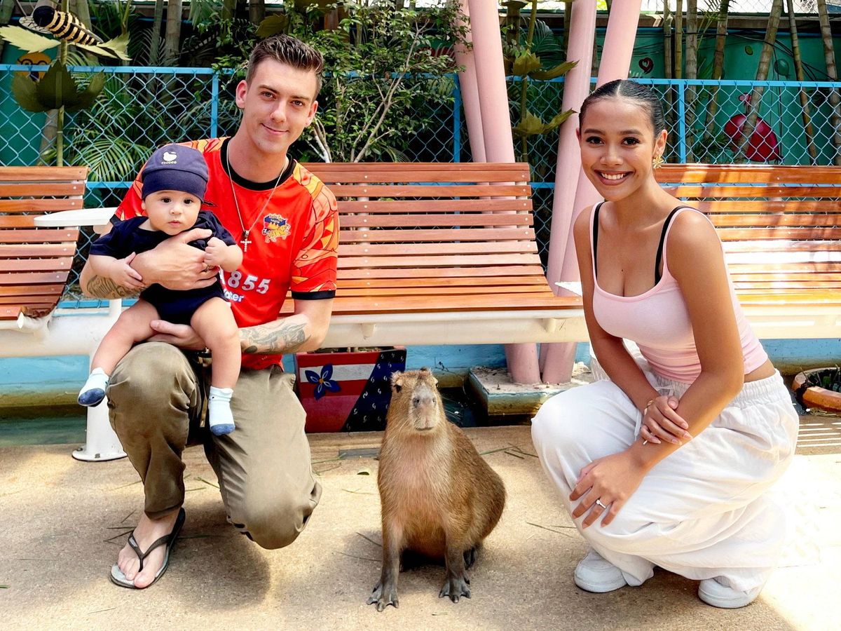 មនុស្ស​ពេញវ័យ​ប្រុស​ស្រី រួម​នឹង​កូន​ក្មេង​កំពុង​ថត​រូប​ក្បែរ​សត្វ​តោ​សមុទ្រ​នៅ​កន្លែង​ខាង​ក្រៅ។